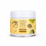 Matcha & Co Mango 50g – Βιολογικό μείγμα ιαπωνικού matcha με μάνγκο, σε κίτρινο και λευκό μεταλλικό βαζάκι.